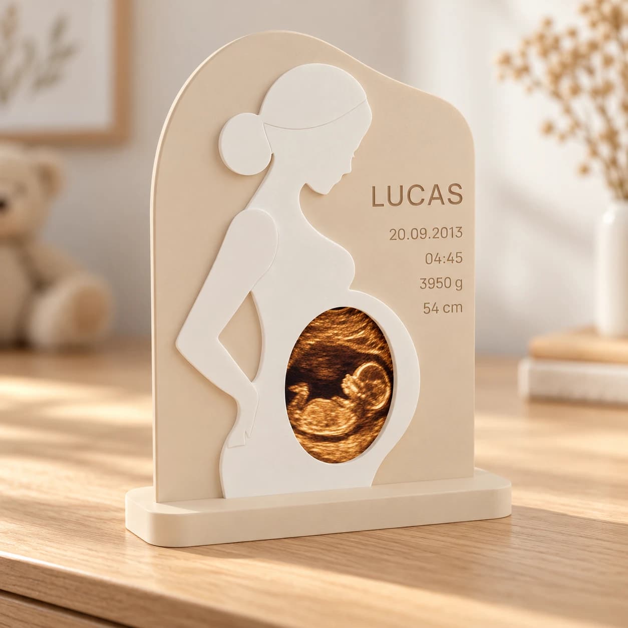 Personlig babygave: gravid silhuet med scanningsbillede og navnet LUCAS på en kommode