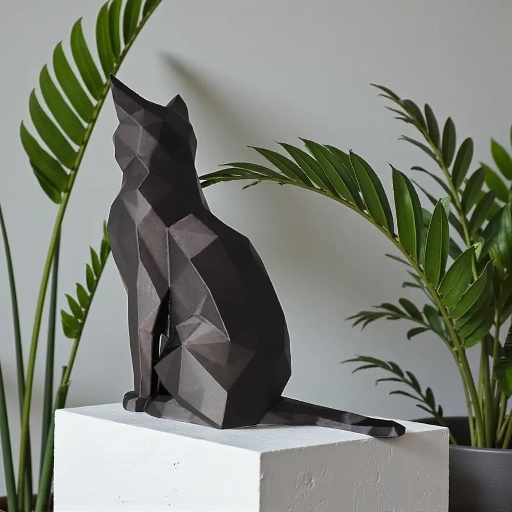 Sort low poly kat set bagfra med lang hale mellem grønne planter