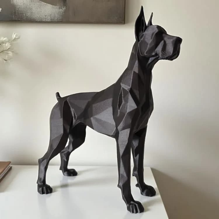 Grand Danois-figur i low poly i mat sort, set fra siden, på hvid skænk med bøger og tørrede blomster