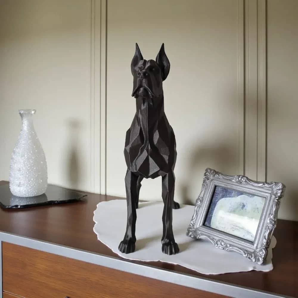 Sort low poly hundefigur set forfra på mørk træskænk ved siden af glasvase og sølvfotoramme