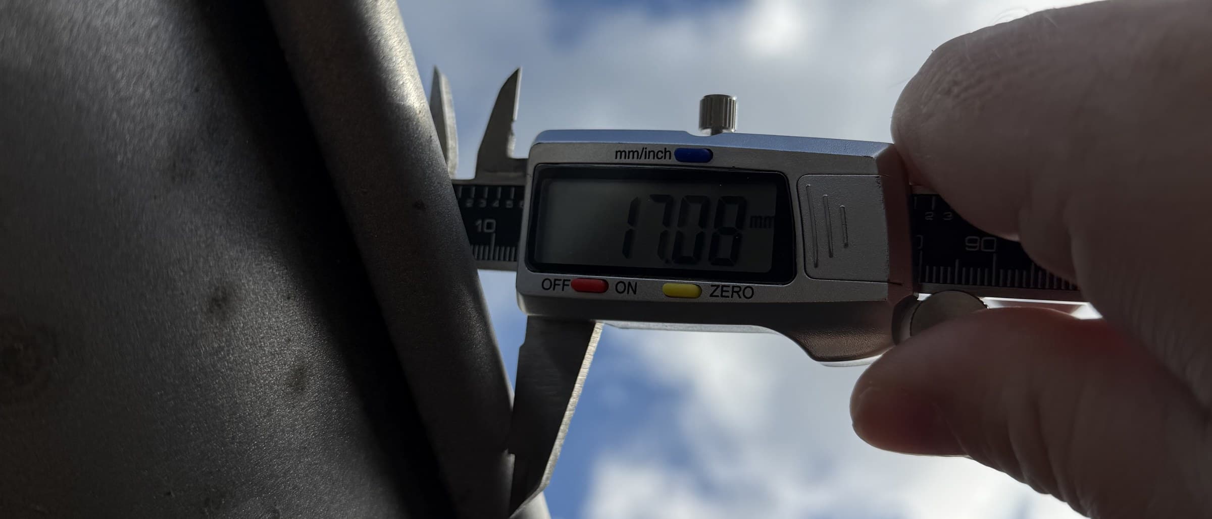 Digital skydelære måler vulsten på en grå metaltagrende: 17,08 mm