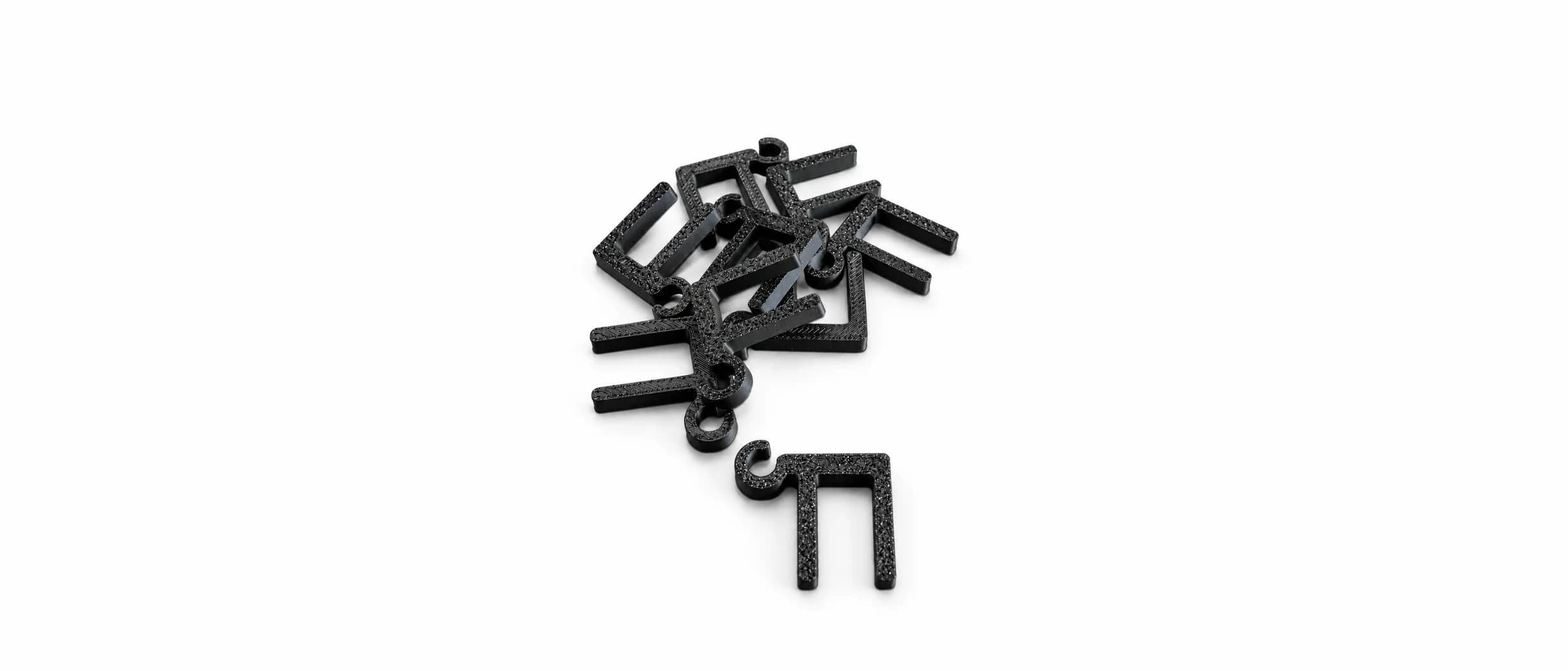 Bunke sorte 3D-printede U-formede clips med lille krog til julelys på hvid baggrund